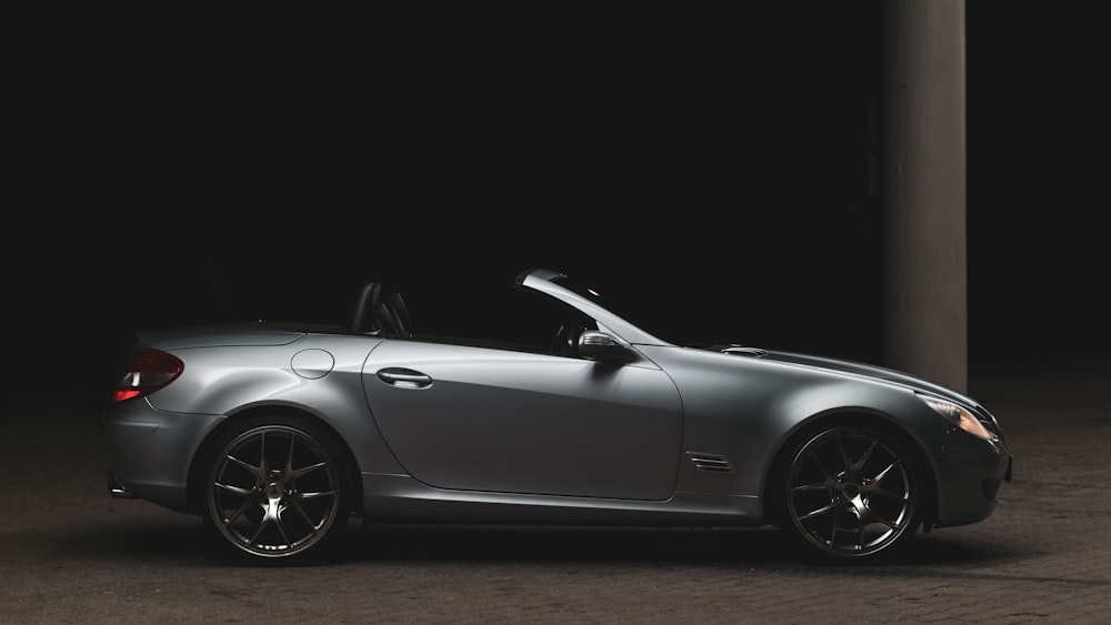 a silver sports car parked in the dark