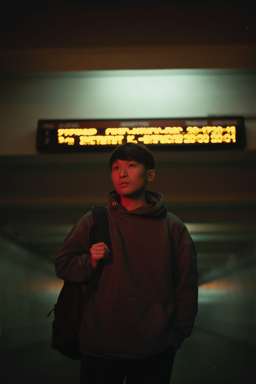 a young man standing in front of a sign