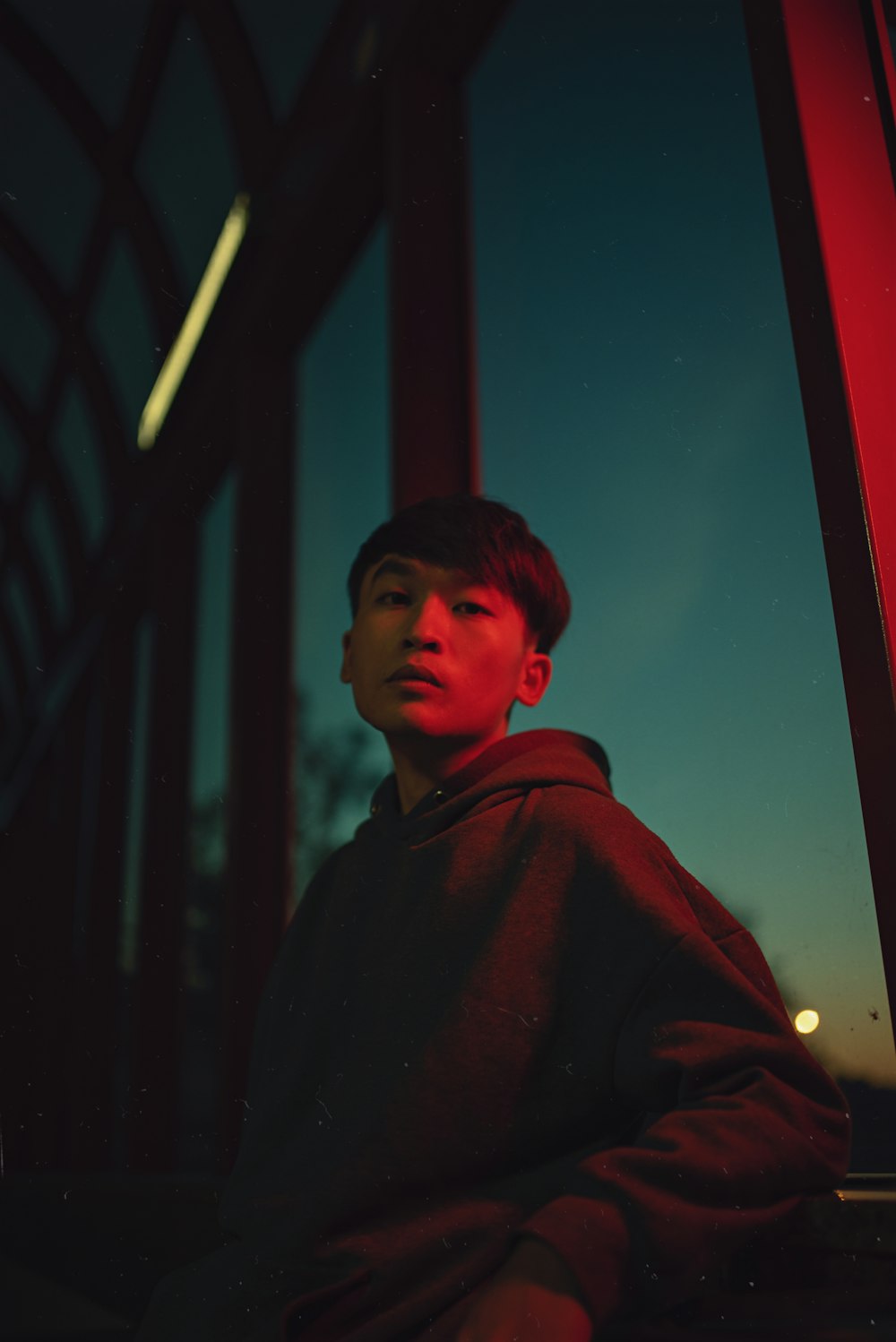 a young man sitting in front of a window