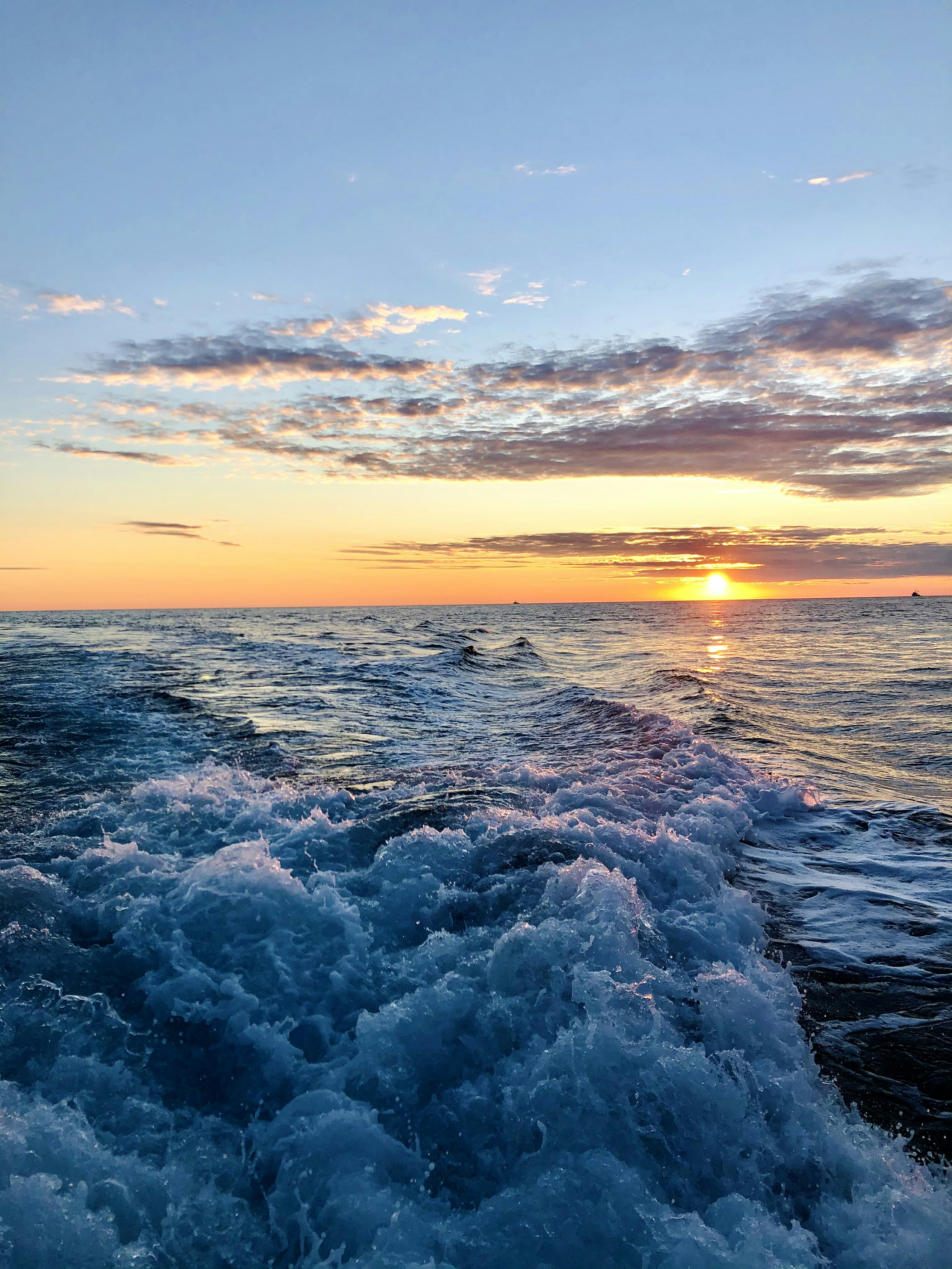 the sun is setting over the ocean waves