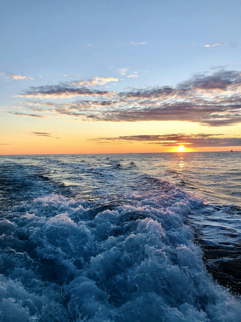 the sun is setting over the ocean waves