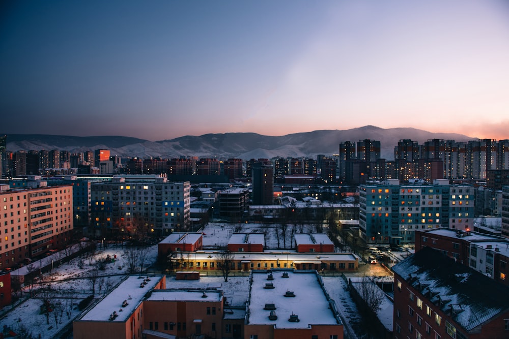 uma vista de uma cidade à noite com neve no chão