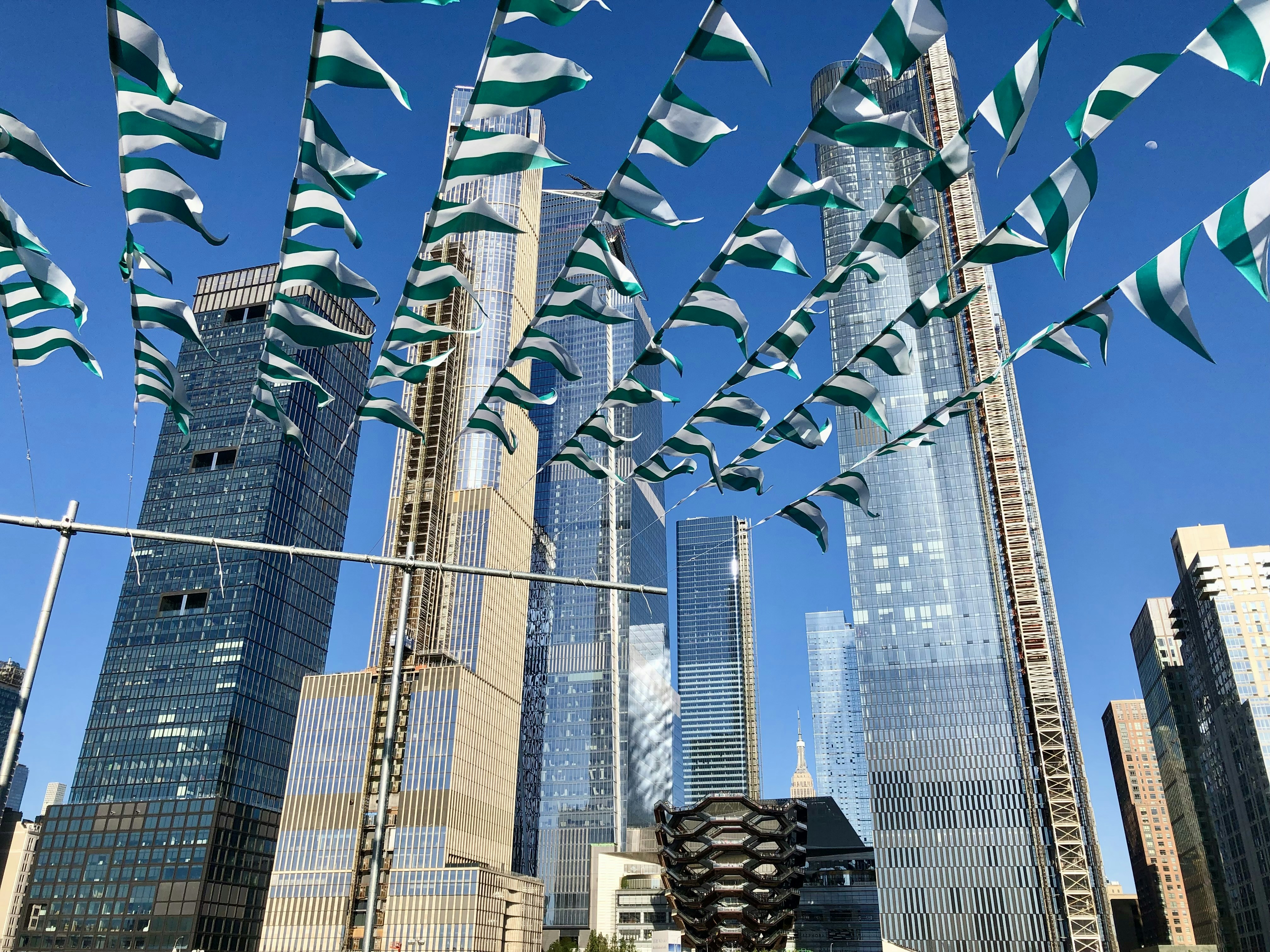 a group of flags flying in the air over a city