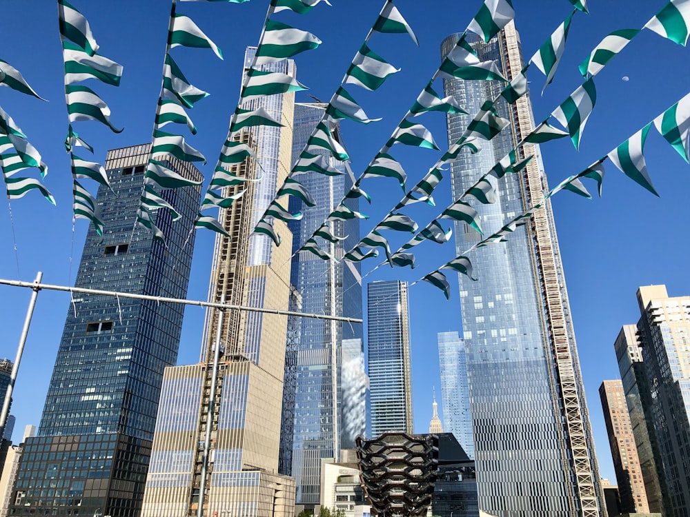 a group of flags flying in the air over a city