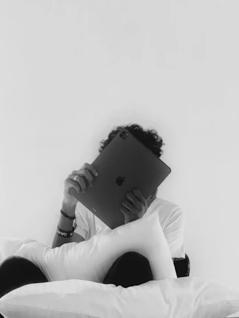 Close-up of hands using an iPad with a sleek, minimalist background.