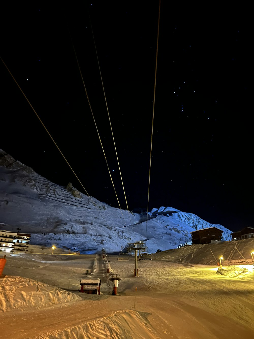 a ski lift going up a snowy mountain at night