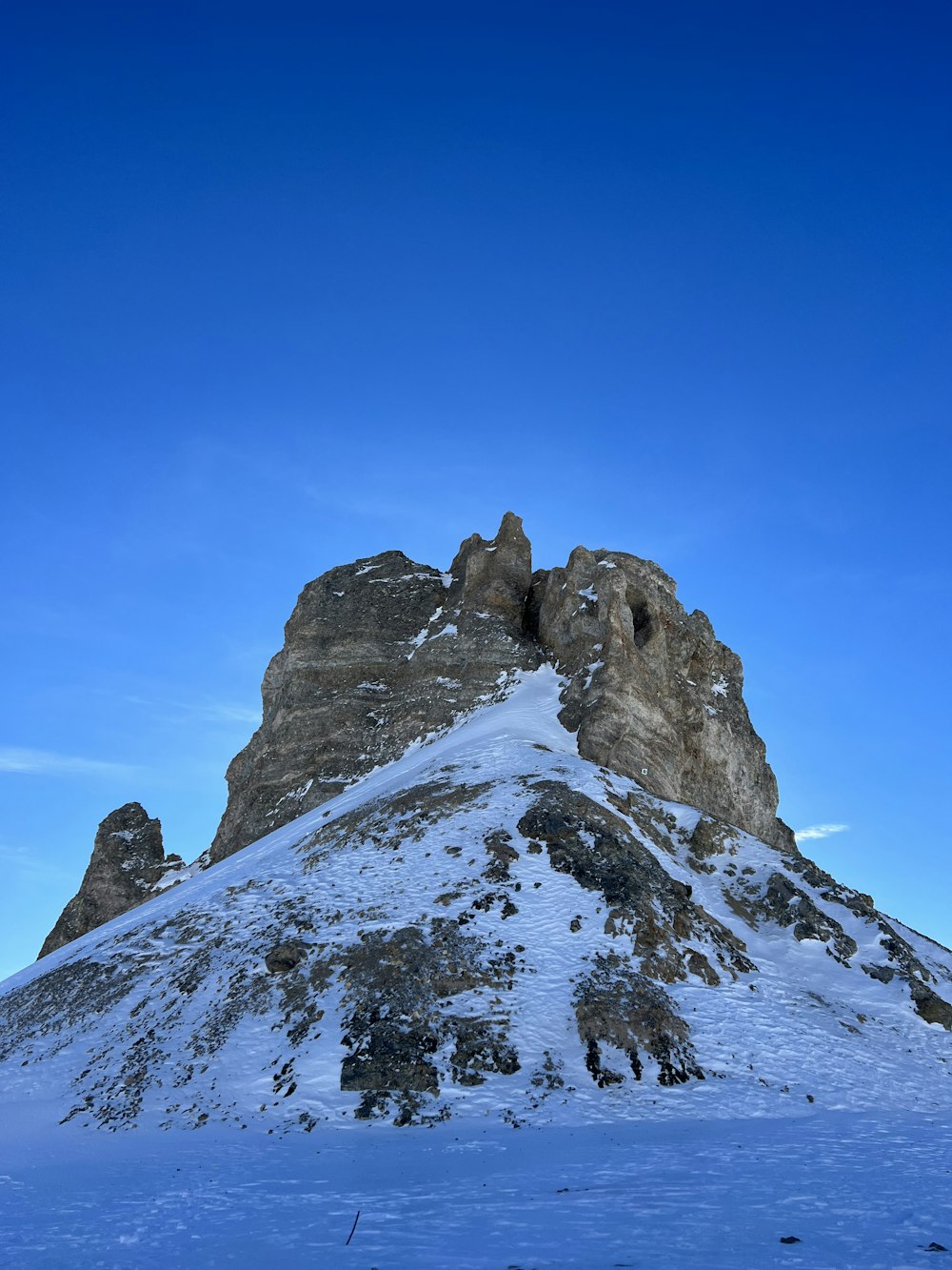 a mountain covered in snow under a blue sky