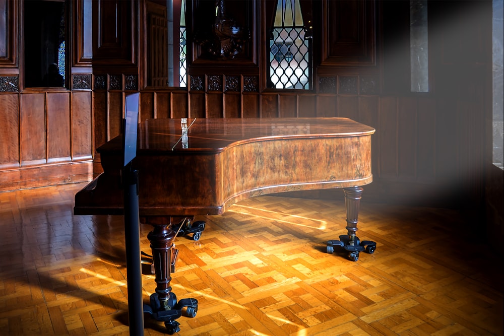 Un piano de cola sentado en un piso de madera