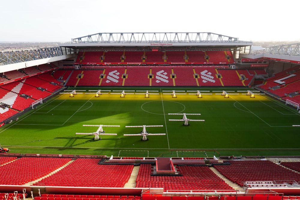 uno stadio di calcio con un campo verde e sedili rossi