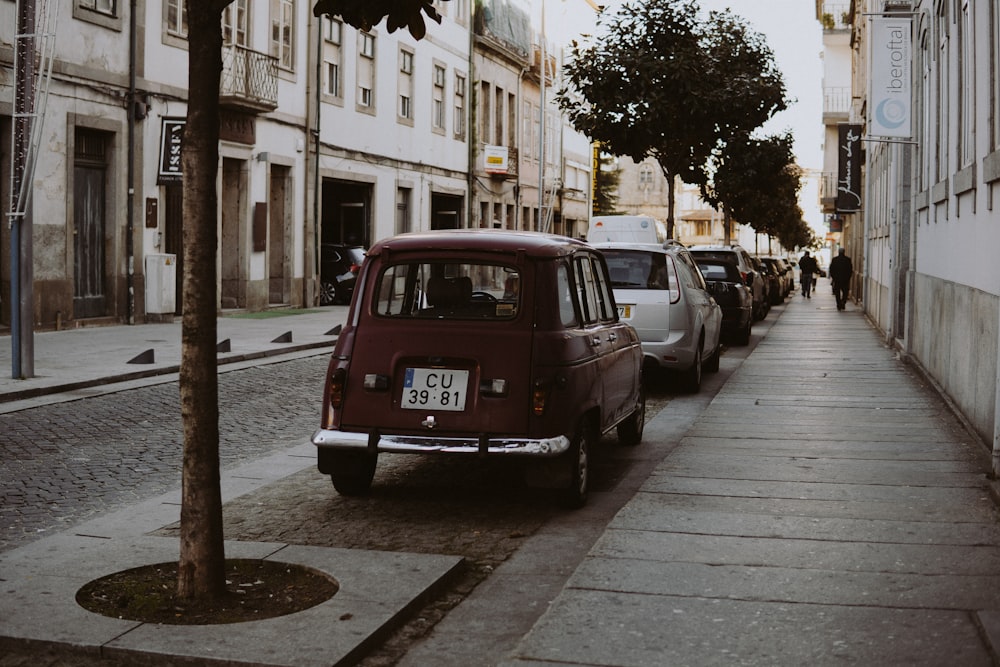 a car parked on the side of a street next to a tree