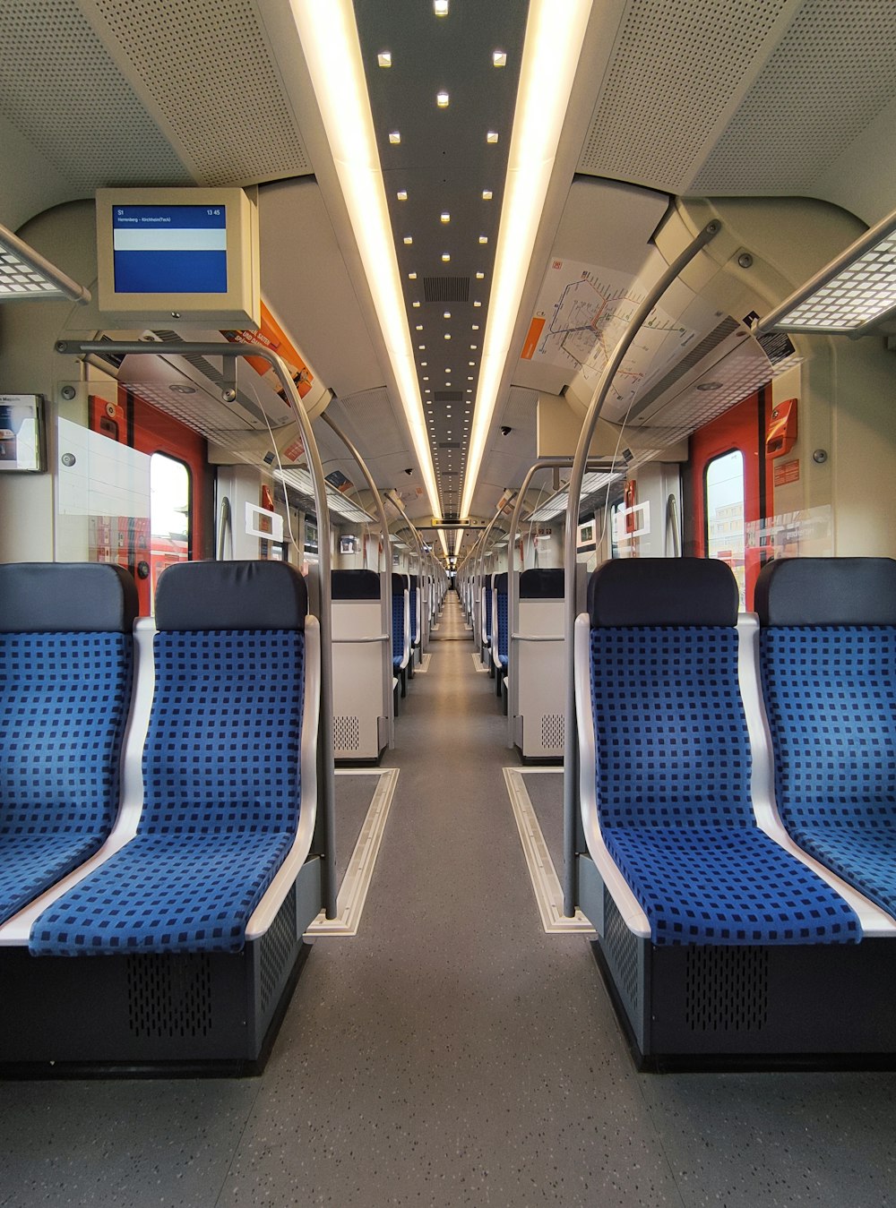 a train car with blue seats and a red door