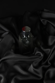 Sleek dark bottle resting on velvet fabric