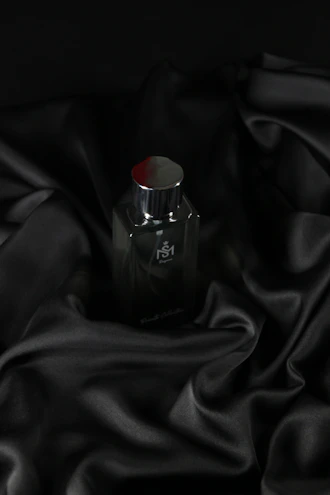 Premium car fabric spray bottle with oriental spice and floral notes, set against a dark wood background.