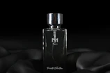 a bottle of perfume sitting on top of a black cloth