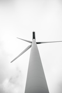 a tall white pole with a wind turbine on top of it