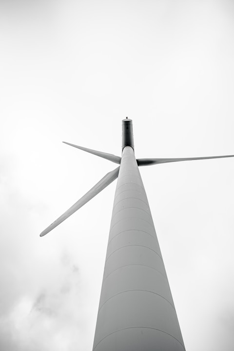 a tall white pole with a wind turbine on top of it
