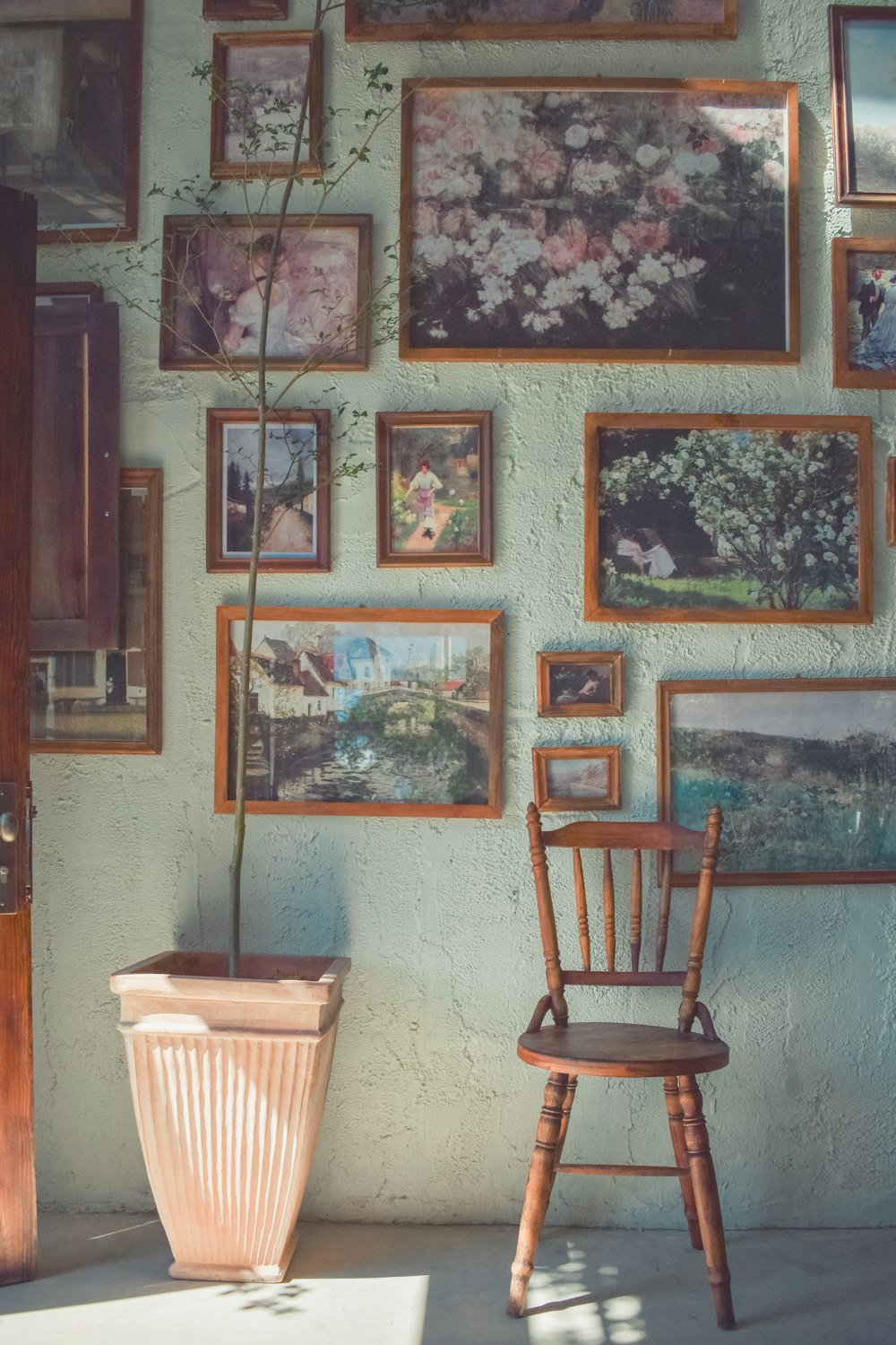 a chair sitting in front of a wall covered in pictures