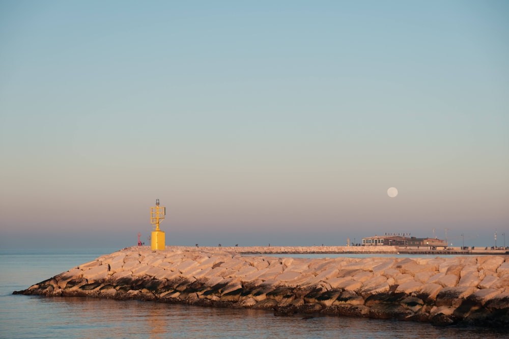 a light house sitting on top of a rock pier