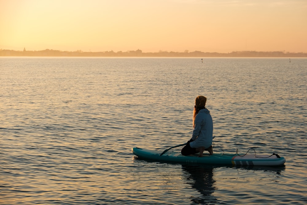 a person sitting on a surfboard in the water