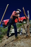 A maintenance worker repairing a fence around a residential property.