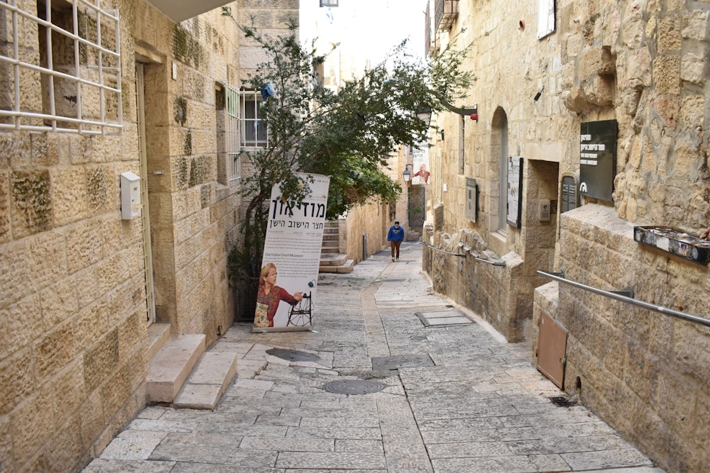 a narrow street with a sign on the side of it