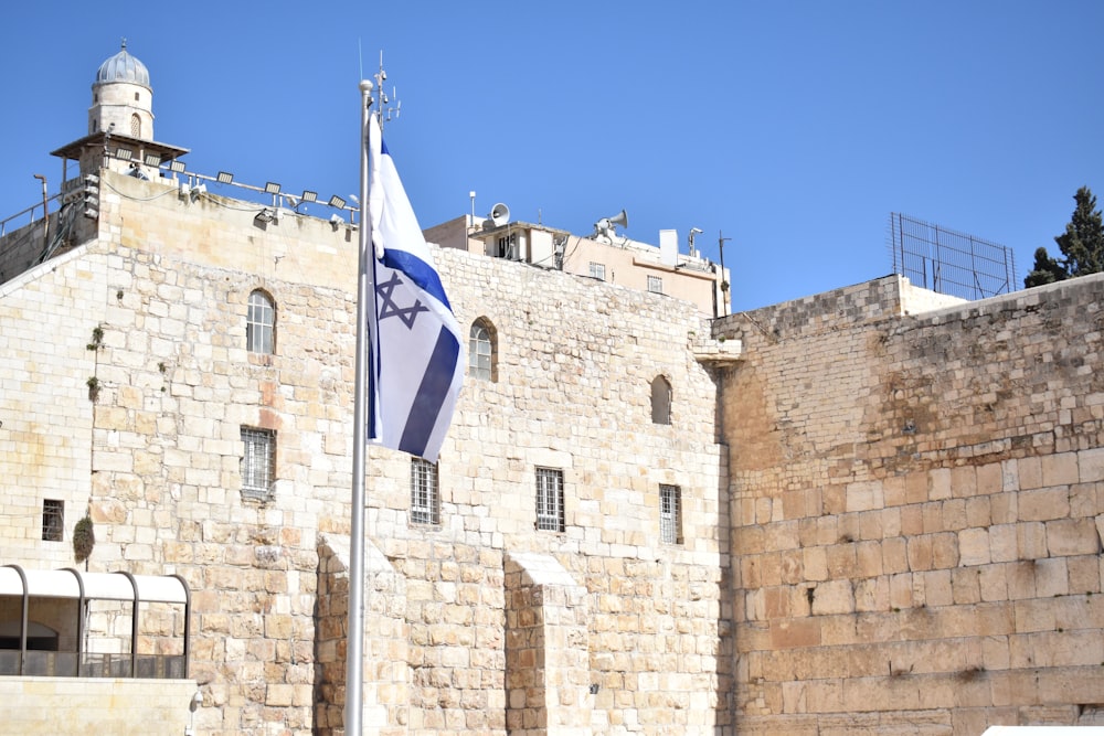 a flag flying in front of a stone building