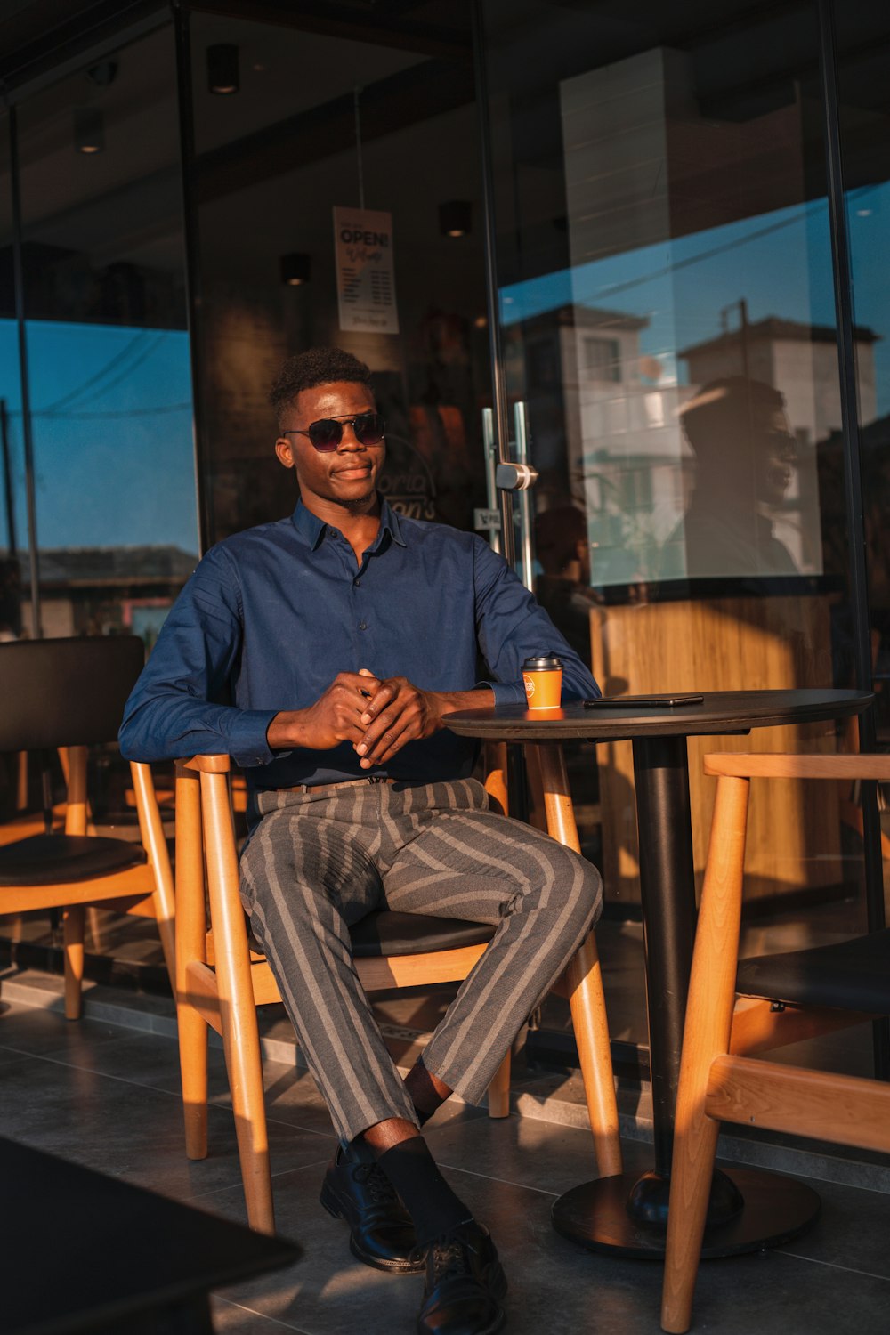 a man sitting at a table with a cup of coffee