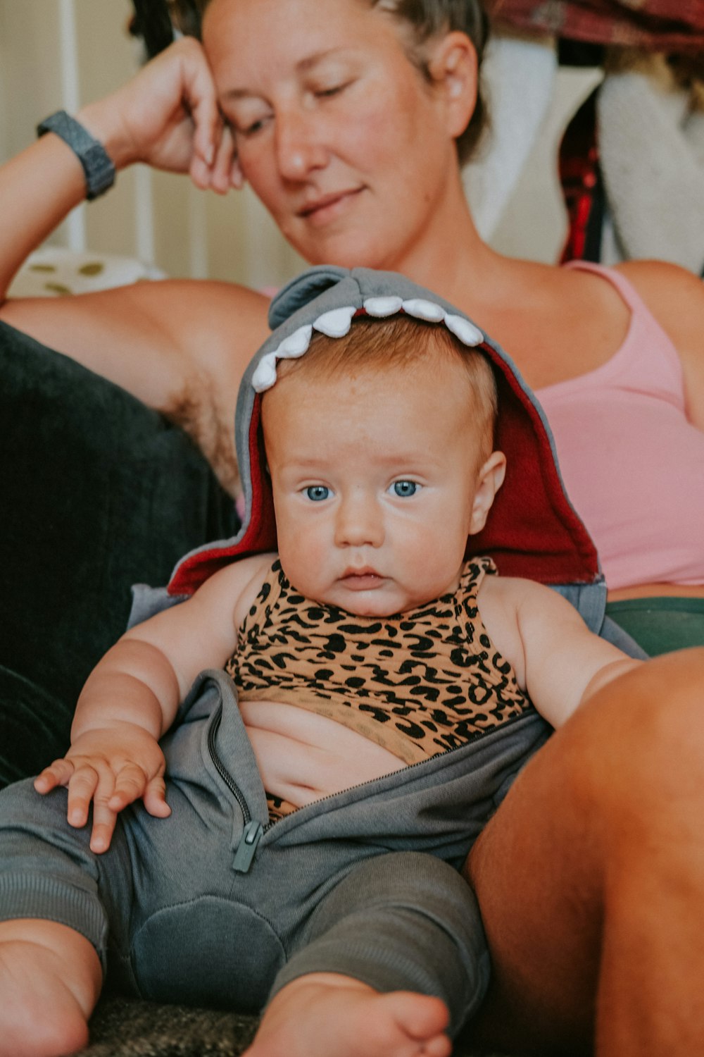 a woman sitting next to a baby on a couch