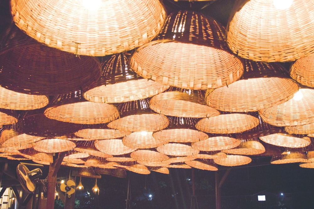 a bunch of wicker lamps hanging from the ceiling