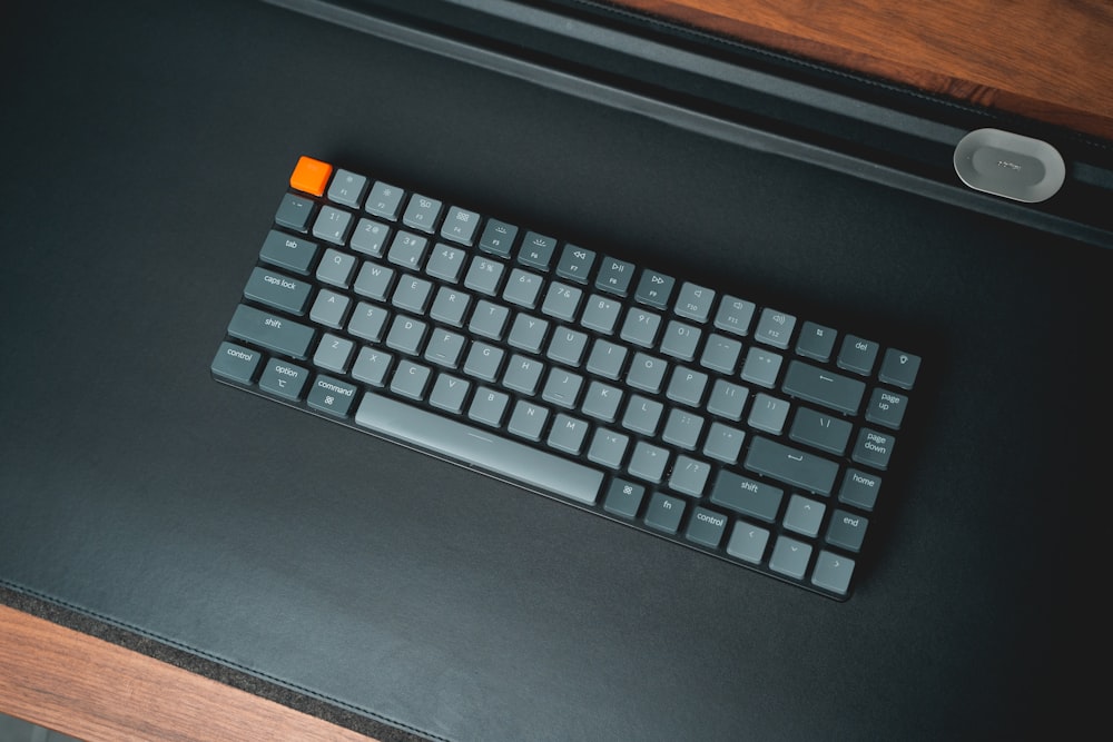 a computer keyboard sitting on top of a wooden desk