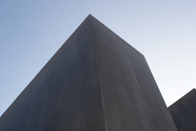 Drone flying over a minimalist architectural structure with sharp lines.