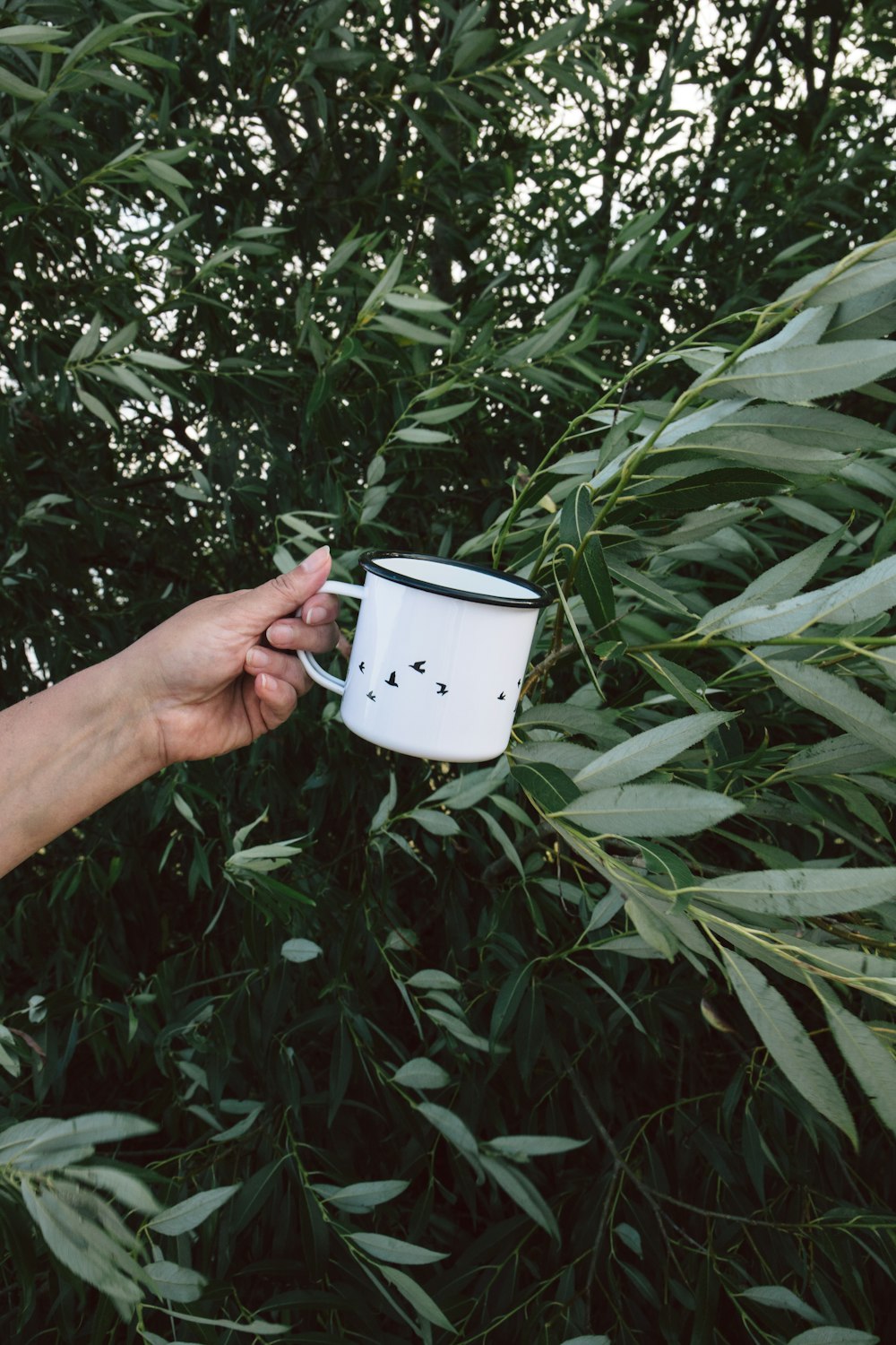 a person holding a coffee mug in their hand