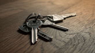 Set of shiny new keys neatly arranged on a wooden table.