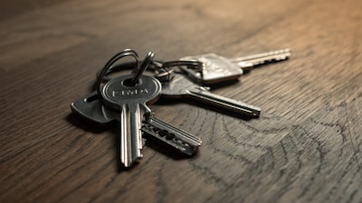Set of shiny new keys neatly arranged on a wooden table.