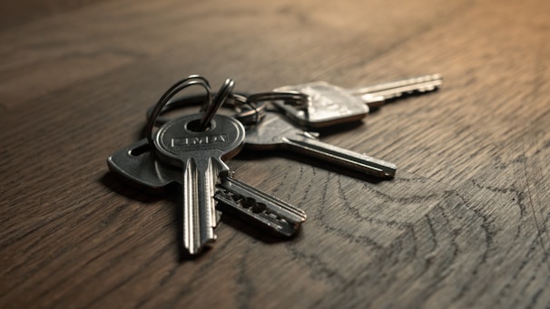 A quiet room with vintage keys scattered on a wooden table under soft sunlight.