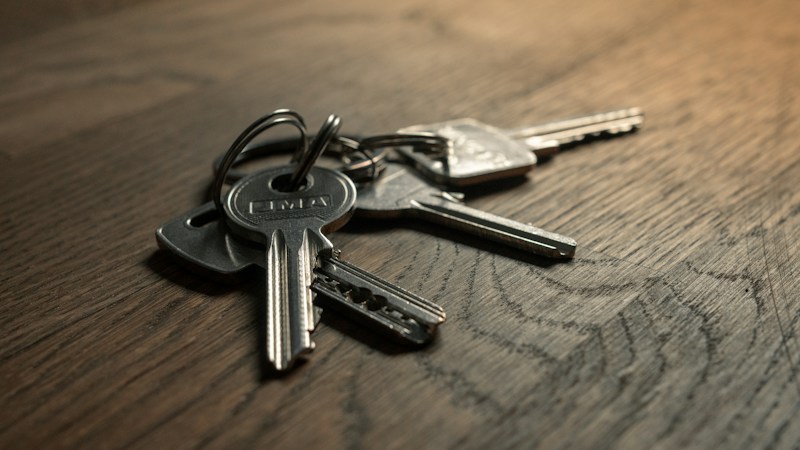 A set of house keys resting on a wooden table, representing options available to Clark County homeowners who fall behind on a mortgage