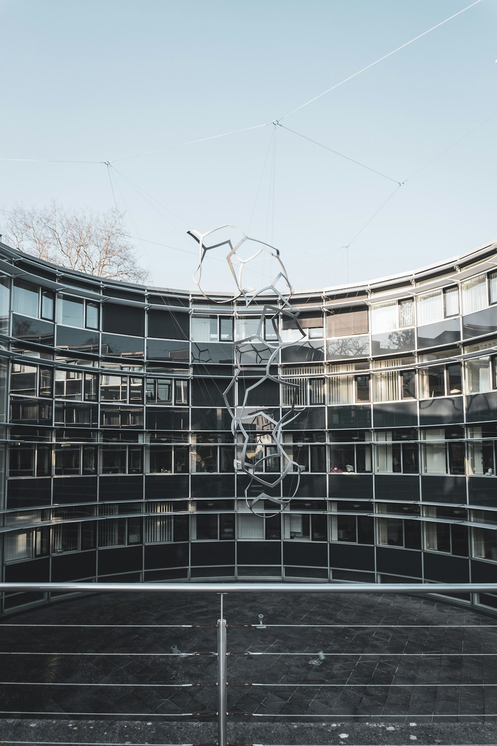 a circular building with many windows and a metal fence