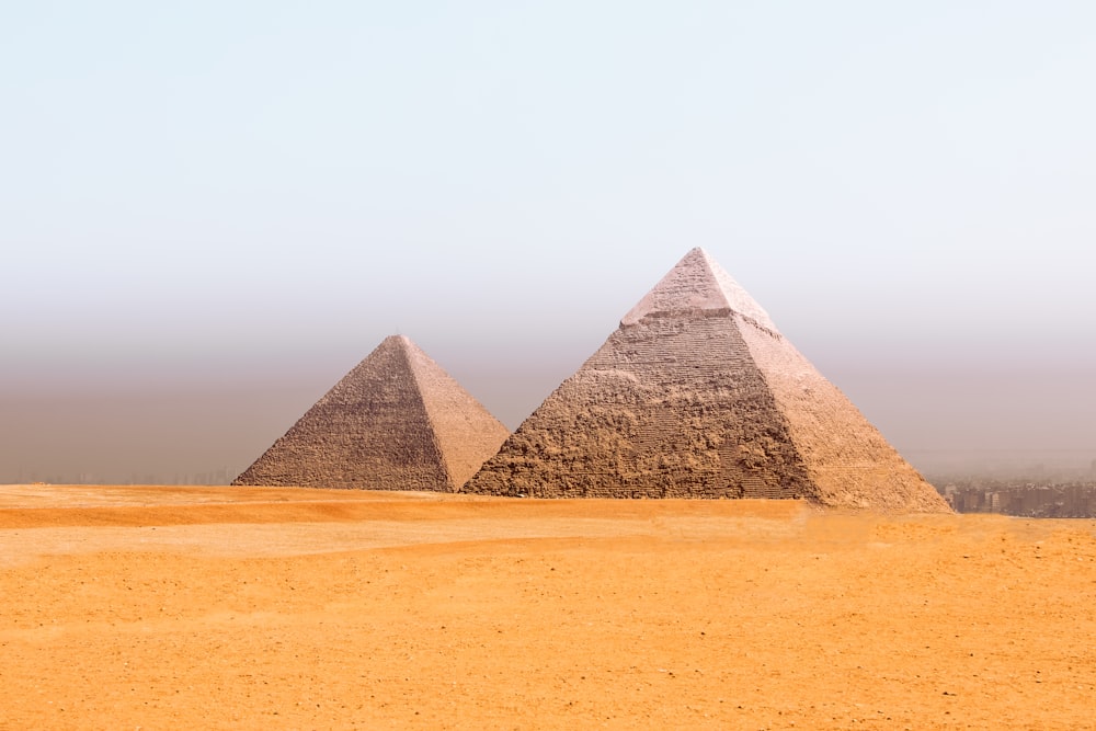 a group of three pyramids in the desert