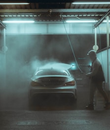 a man washing a car in a garage