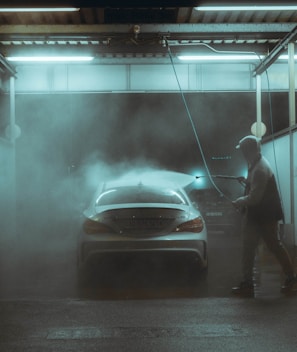a man washing a car in a garage