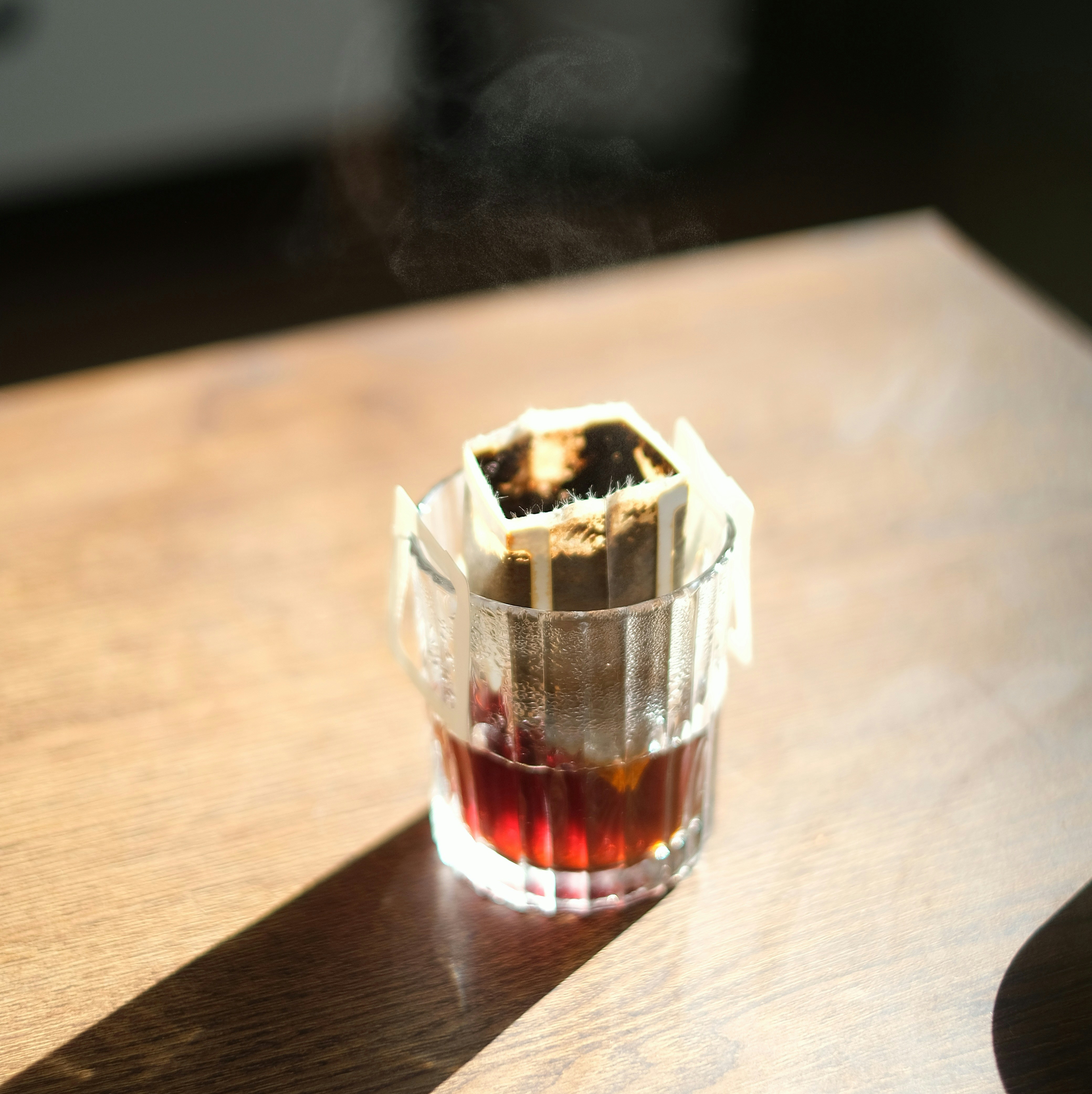 a glass filled with liquid sitting on top of a wooden table