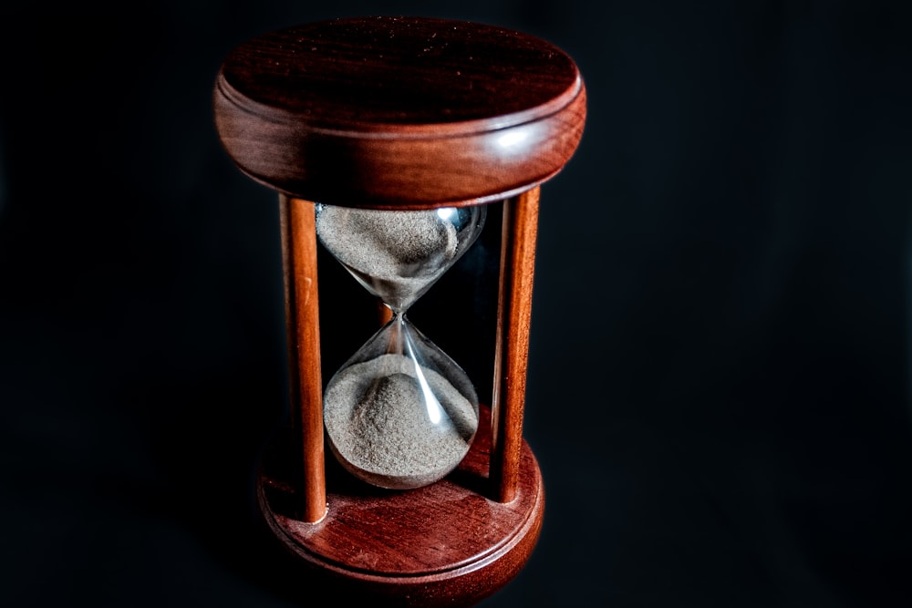 an hourglass with sand in it on a black background