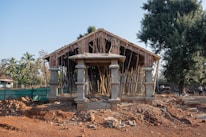 a wooden structure sitting on top of a dirt field