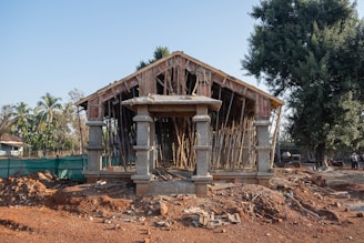 a wooden structure sitting on top of a dirt field