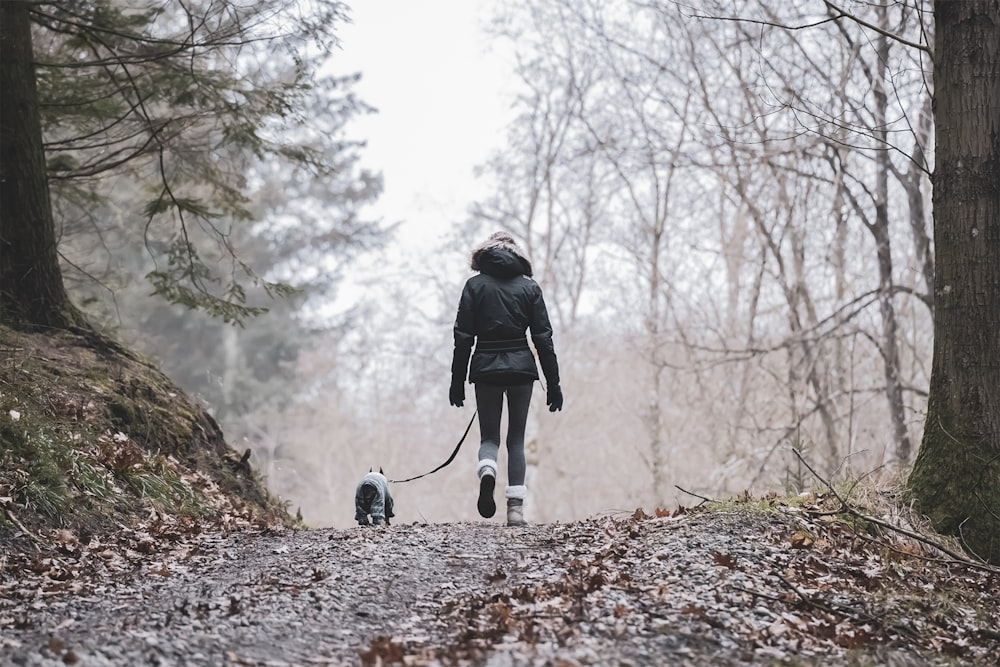 a woman walking her dog in the woods