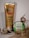 A tube of Satsuma-scented hand cream from The Body Shop stands beside a small circular container of Sugar Lip Scrub labeled as a vegan product. Both are surrounded by decorative curled paper. The hand cream features cold-pressed satsuma oil from Argentina, and the lip scrub is called Kindness & Pears, offering nourishing exfoliation.