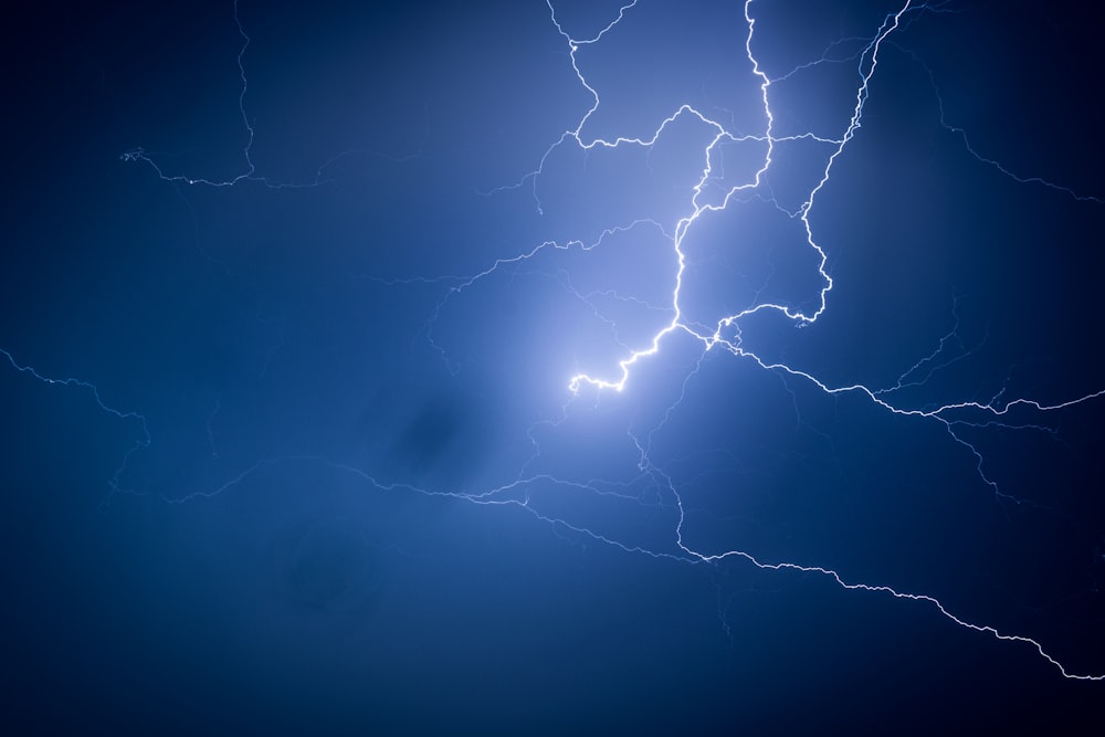 a lightning bolt is shown in the dark blue sky photo – Free Thunderstorm  Image on Unsplash
