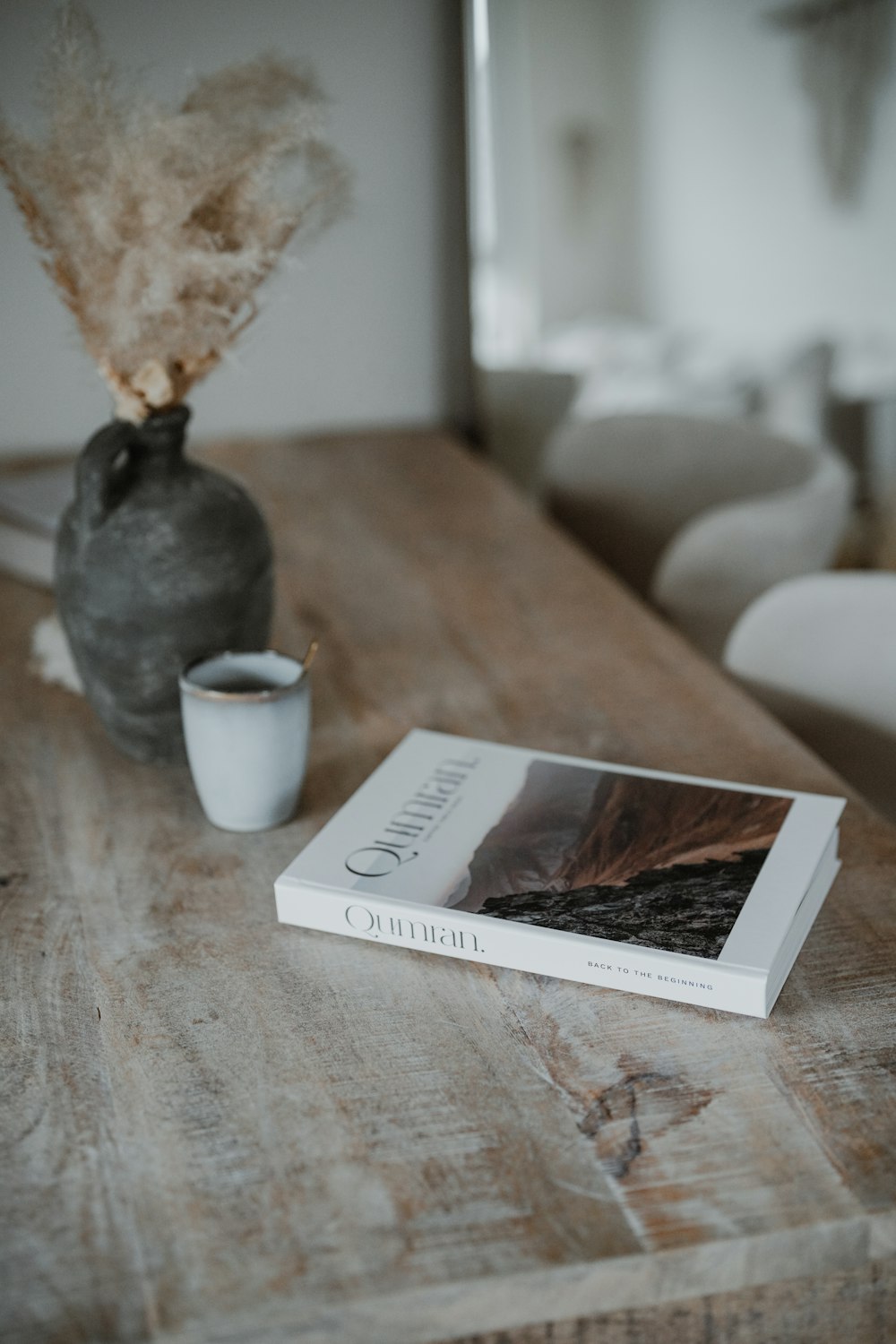 Ein Buch auf einem Holztisch neben einer Tasse Kaffee