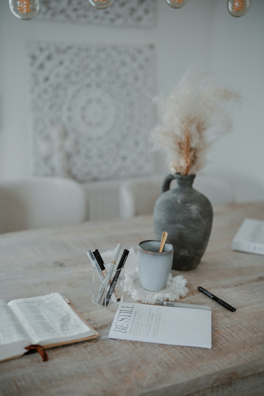 a wooden table topped with a vase filled with feathers