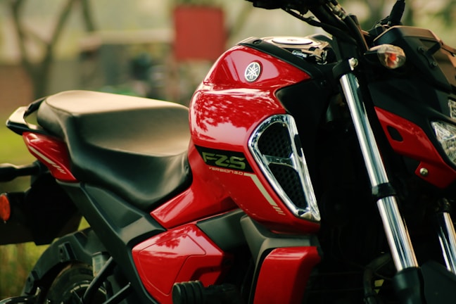 A close-up of a Yamaha Fascino against a rustic café backdrop.